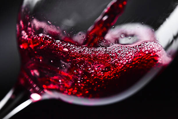 Botella de vino llenándose para poder beber vino